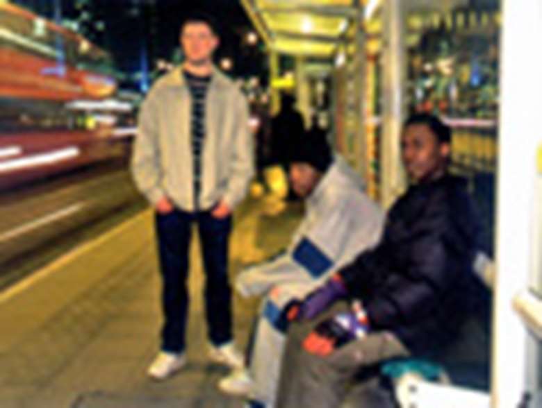 Young men waiting at a bus stop. Credit: Alex Deverill